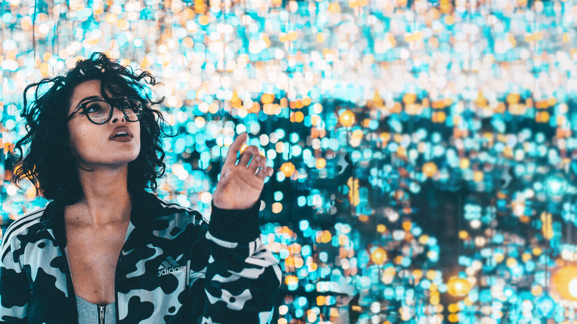 Google Analytics 4 webinar - photo of a woman with large black curly hair, surrounded by magical looking lights.