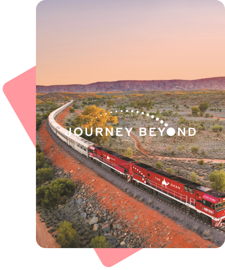 Photograph of a long red and white train, snaking it's way through the Australian outback. Overlayed on the photo is the logo for "Journey Beyond".