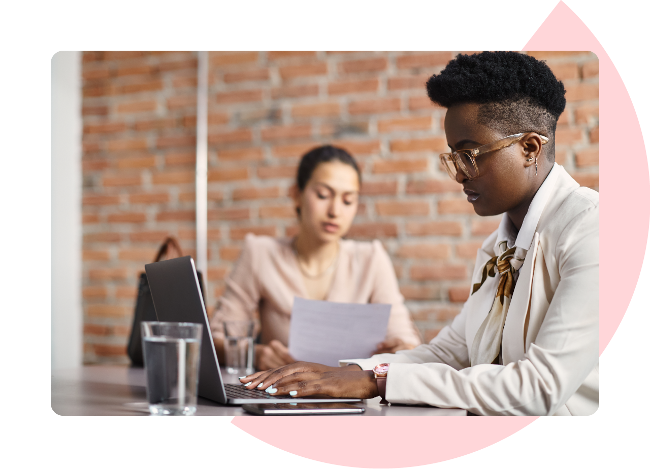 African American female working on a laptop while a UX researcher observes and takes notes