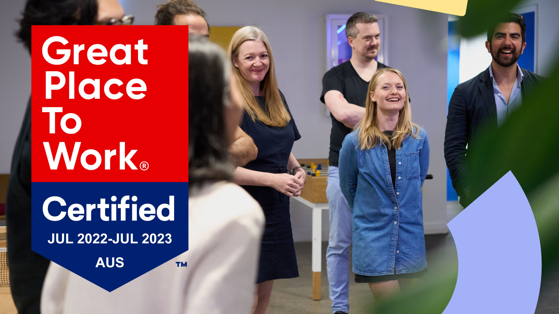 Image of a group of Sitback employees standing together and laughing. Overlayed is a badge saying that Sitback is Great Place To Work certified from July 2022 to July 2023.