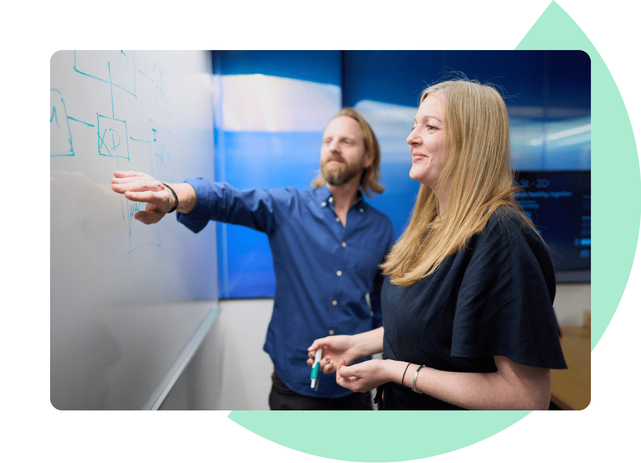 Services - Technical Advisory. A man and a woman pointing at words on a whiteboard.