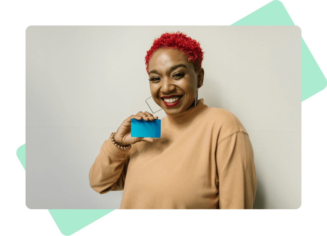 Young woman with short bright red hair holding up a credit card