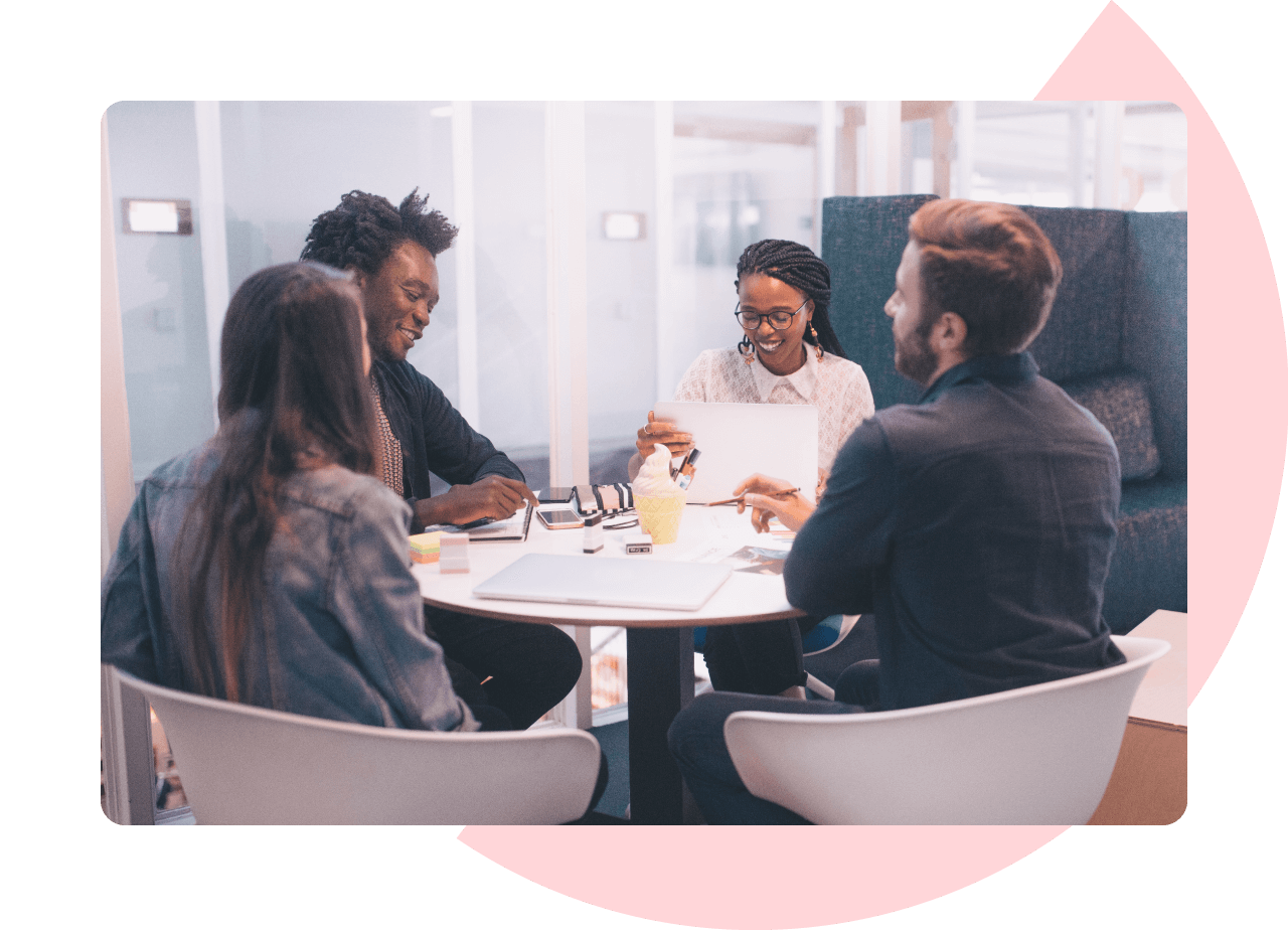 2 men and 2 women sat around an office table looking at business metrics