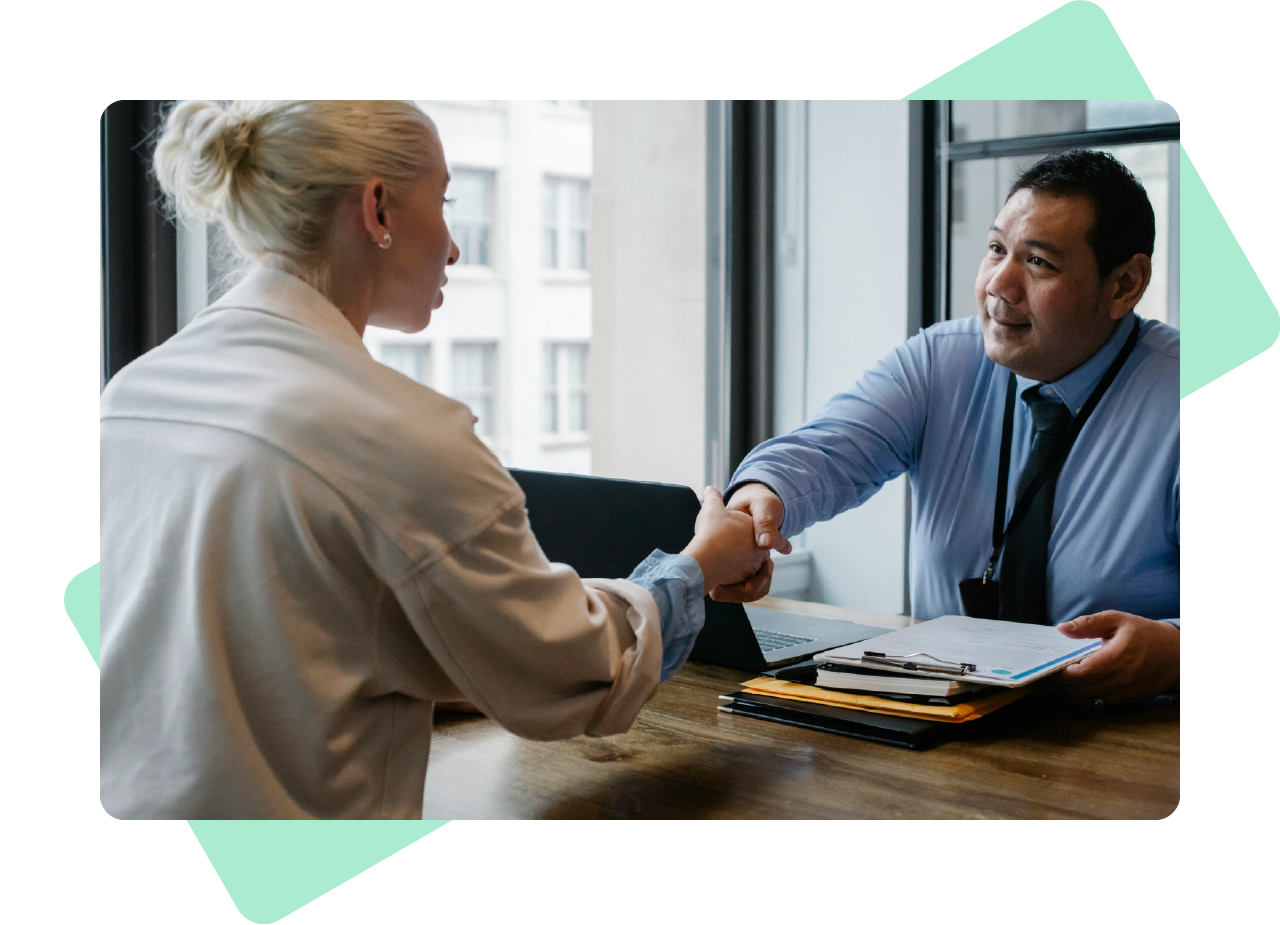 Man and woman shaking hands over a desk