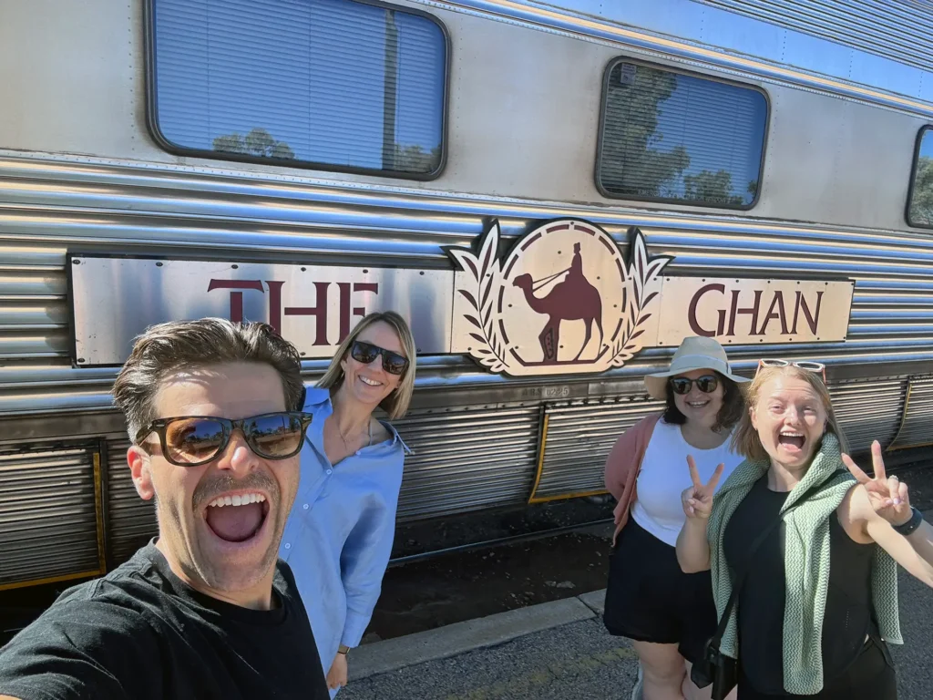 Sitback and Journey Beyond smiling as a group on the platform outside The Ghan train