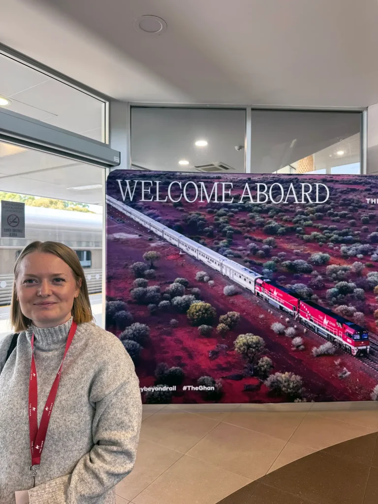 Rebeka Hall from Sitback standing in front of a large banner saying welcome aboard