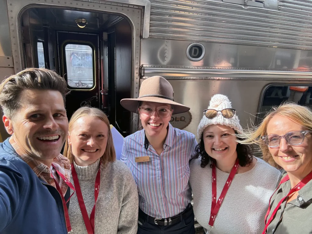 Sitback and Journey Beyond standing in front of the Ghan train, as their adventure begins.