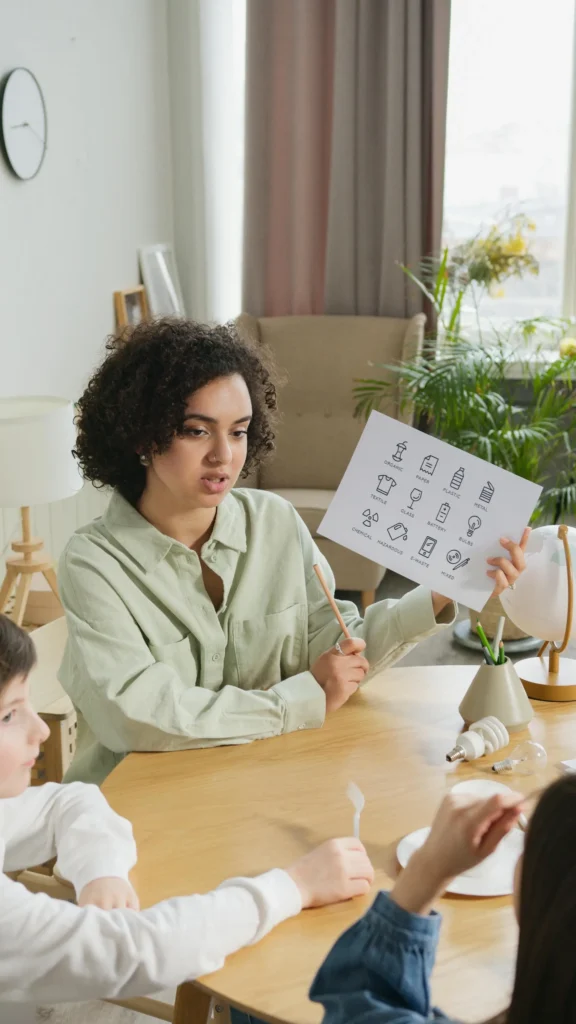 A female teacher holding up an AAC Flashcard in front of students in a specialist school.